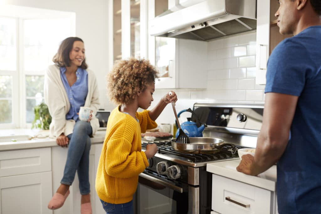 Young family spending time together while preparing food in their kitchen