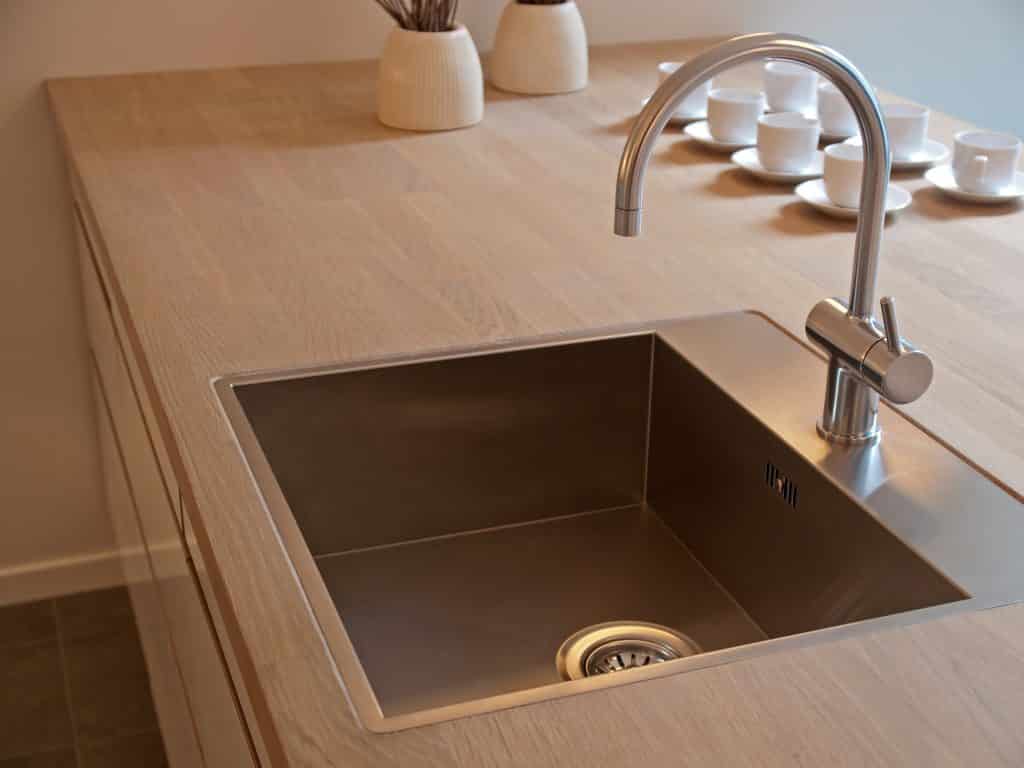 Modern, square kitchen sink with sleek curved faucet