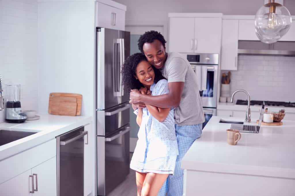 Couple embracing in their new kitchen